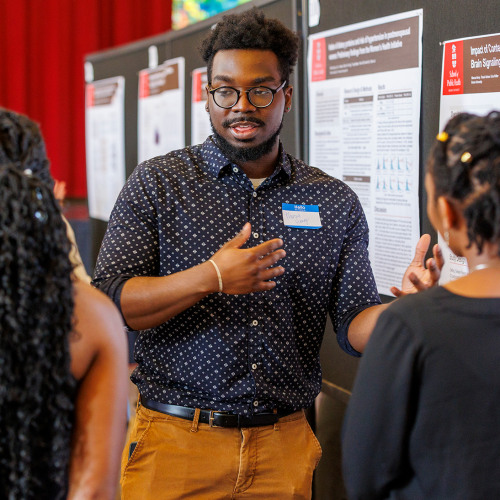 Student giving poster presentation at event